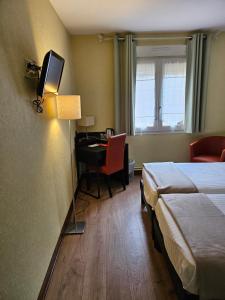 una camera d'albergo con letto e scrivania con computer di Hotel du Saumon, Verneuil sur Avre a Verneuil d'Avre et d'Iton