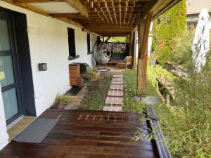 a porch of a house with a wooden deck at Joli Appartement Cosy 2 à 4 pers avec terrasse La Fourmi in Orbey +2 photos