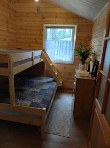 Habitación con litera en una cabaña de madera en Domek pod sosnami en Grodziczno