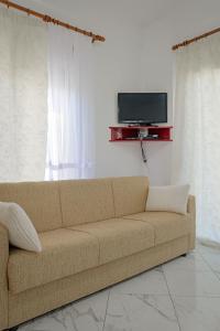 a brown couch in a living room with a tv at Valentina Apartment 1 in Sarandë