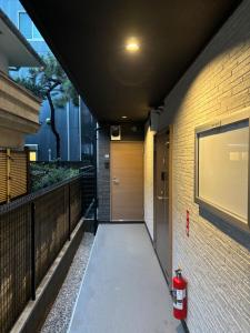 um corredor com uma boca de incêndio ao lado de um edifício em IXO Ts1 em Tóquio
