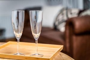 zwei Champagner-Gläser auf einem Holztablett auf dem Tisch in der Unterkunft Old Dairy Cottage - Cosy and Luxurious! in Buckinghamshire + 4 Fotos