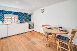 eine Küche mit Tisch und Stühlen in einem Zimmer in der Unterkunft Old Dairy Cottage - Cosy and Luxurious! in Buckinghamshire