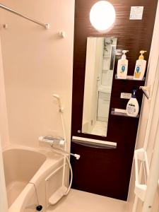 uma casa de banho com uma banheira e um espelho. em IXO Ts1 em Tóquio