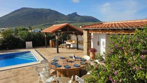 a patio with a table and chairs next to a pool at Villa Lolo in Loja