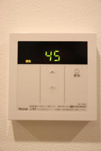 a digital clock on a wall with a clock on it at IXO Ts1 in Tokyo