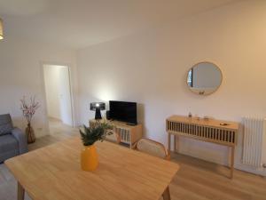 a living room with a table and a tv at Apartment Haridian by Interhome in Porto Valtravaglia