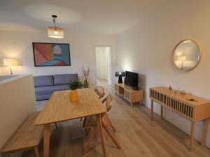 a living room with a table and a blue couch at Apartment Haridian by Interhome in Porto Valtravaglia