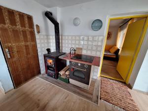 a kitchen with a stove in a room at Lesný domček in Hunisky