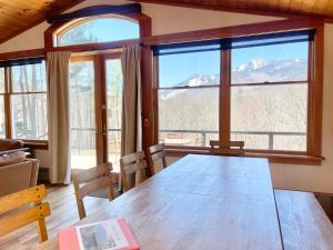 a dining room with a table and views of mountains at Algonquin Mountain Chalet in Wilmington