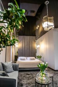CzerwionkaにあるHotel Biały Domのベッドとソファとテーブルのある寝室