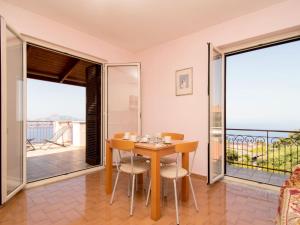 een eetkamer met een tafel en stoelen en een balkon bij Apartment Tramonto su Capri by Interhome in Massa Lubrense