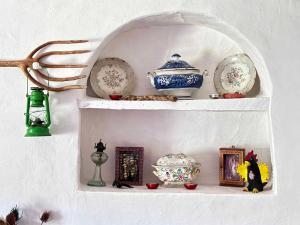 a white shelf with plates and dishes on it at The Stream House - Montes da Ronha in Zambujeira do Mar