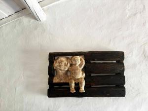a statue of two monkeys on a wall at The Stream House - Montes da Ronha in Zambujeira do Mar +44 photos