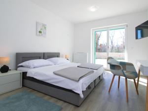 a bedroom with a bed and a desk and a chair at Holiday Home Skelin by Interhome in Drinovci