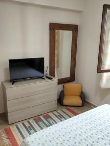 a bedroom with a tv on a dresser with a mirror at Turi house in Messina
