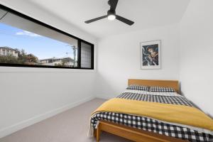 1 dormitorio con cama y ventana grande en Modern Freshwater Beach Pad, en Queenscliff
