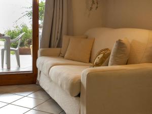 a white couch sitting in a room with a window at Apartment 0-5-F - Marineledda by Interhome in Golfo Aranci