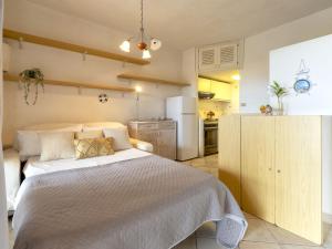a bedroom with a white bed and a kitchen at Apartment 0-5-F - Marineledda by Interhome in Golfo Aranci +33 photos