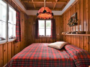 a bedroom with a bed with a plaid blanket at Chalet Chalet Franca by Interhome in Madesimo