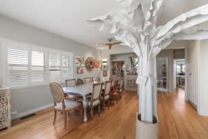 a dining room with a table and a tree at Warriewood Beach Pad in Mona Vale