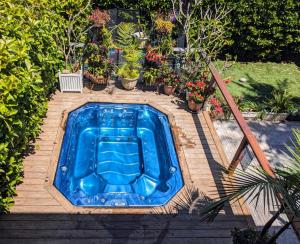 a blue hot tub on a wooden deck with potted plants at Warriewood Beach Pad in Mona Vale