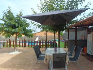 un tavolo e sedie con ombrellone su un patio di Villa Zen a El Vendrell