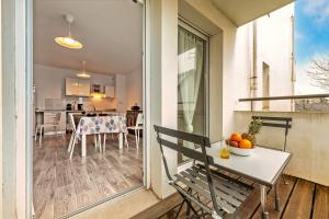 un patio con tavolo e sedie su un balcone di Au Pays des Fraises - Appt à proximité des plages a Plougastel-Daoulas Altre 5 foto