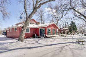 una casa roja en la nieve con un árbol en Waterfront Forest Lake Studio with Shared Dock!, en Forest Lake