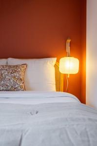 a bedroom with a white bed with a lamp at 1 bedroom courtyard house typical of Old Lille in Lille