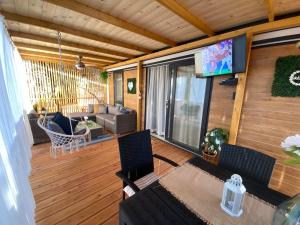 a screened in porch with a couch and a television at Summer Stay - Mobile Home in Biograd na Moru