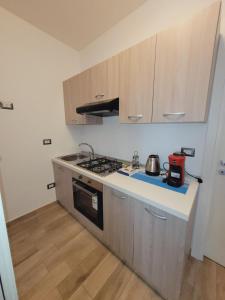 a kitchen with wooden cabinets and a stove top oven at HOUSE AIRPORT VINCENZO APP.7 - APP.8 in Catania