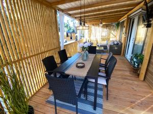 a patio with a table and chairs on a deck at Summer Stay - Mobile Home in Biograd na Moru