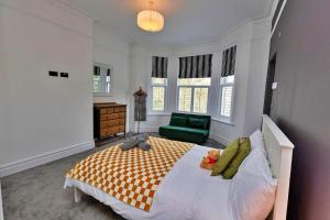a bedroom with a large bed and a green chair at Finest Retreats - Portland House in Exmouth