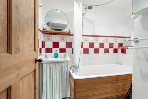 a bathroom with a tub and a sink and a mirror at Mill Cottage - Cosy & Quaint Cottage - 10 mins from St Andrews in Boarhills