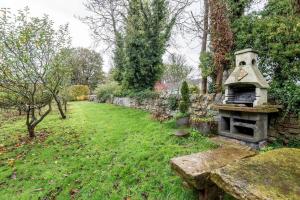a garden with an outdoor oven in the grass at Mill Cottage - Cosy & Quaint Cottage - 10 mins from St Andrews in Boarhills