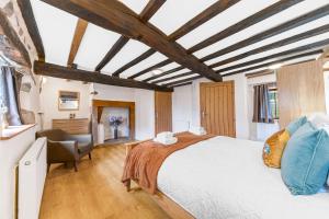 a bedroom with a large bed and a desk at Damson Cottage in Waberthwaite