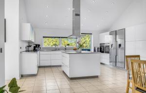 una gran cocina blanca con armarios y electrodomésticos blancos en Amazing Home In Jerup With Wifi en Jerup