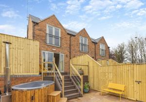 a house with a wooden fence and a hot tub at The Pear Tree - Pershore in Pershore