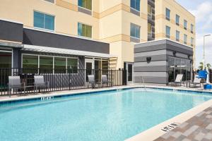 a large swimming pool in front of a building at Fairfield by Marriott Inn & Suites Orlando at Millenia in Orlando