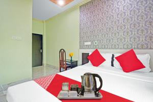 a hotel room with a bed with red pillows at Collection O 87025 Pink House in Madhyamgram