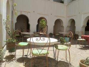 a room with chairs and a table and a table and chairs at Hotel et Restaurant Riad Amodou in Tinerhir