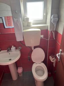a bathroom with a toilet and a sink and a window at Apartmani Marković in Tivat