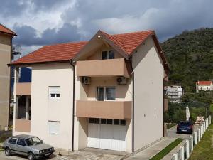 a house with a car parked in front of it at Apartmani Marković in Tivat