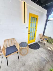 a porch with two chairs and a yellow door at The Hideaway DT Orlando Tiny Home w Free Parking in Orlando