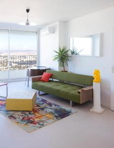 ein Wohnzimmer mit einem grünen Sofa und einem Tisch in der Unterkunft Panoramic view of Marseille for two in Marseille