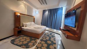 a hotel room with a bed and a flat screen tv at فندق دروب هيلتون in Al Jardāʼ