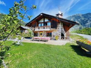 una casa in montagna con un prato di Spacieux Chalet 19pers, Piscine, Jacuzzi, Sauna & Salle de Jeux a Champagny-en-Vanoise