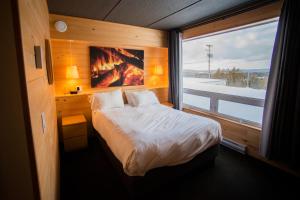 a bedroom with a bed and a large window at Hotel de l'Horizon in Sutton