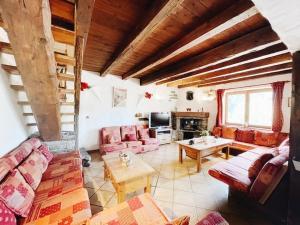 un soggiorno con divani rosa e tavolo di Spacieux Chalet 19pers, Piscine, Jacuzzi, Sauna & Salle de Jeux a Champagny-en-Vanoise